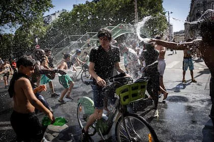 Un grupo de adolescentes se tiran agua en el Canal Saint-Martin en París