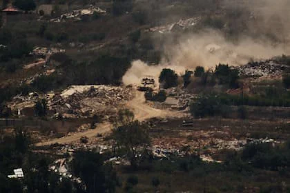 Un tanque israelí avanza junto a edificios destruidos en el sur del Líbano