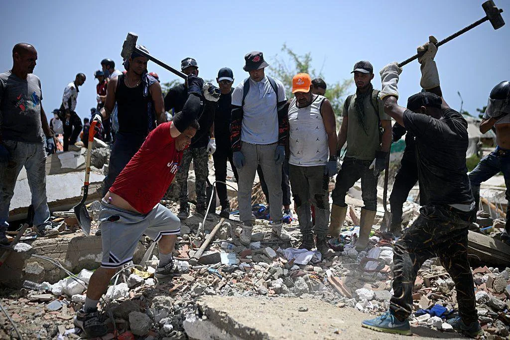 Voluntarios golpean restos de concreto con mazos de hierro buscando sobrevivientes bajo los escombros en La Guaira, Venezuela, 26 de junio 2026