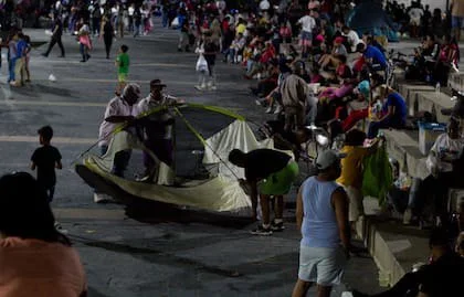 Dos hombres arman una carpa en una plaza caraqueña