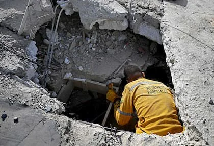 Un voluntario busca posibles víctimas entre los escombros tras un doble terremoto en Caraballeda, estado de La Guaira, a unos 40 kilómetros al noreste de Caracas