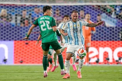 Alexis Mac Allister disputa la pelota con el delantero Adil Boulbina, de Argelia