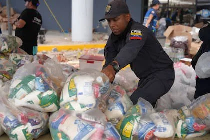 Efectivo de la Policía Nacional Bolivariana acomodando bolsas con víveres en un refugio en La Guaira, Venezuela, el 28 de junio de 2026