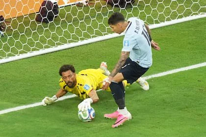 Vozinha y una de sus grandes atajadas, frente a Uruguay