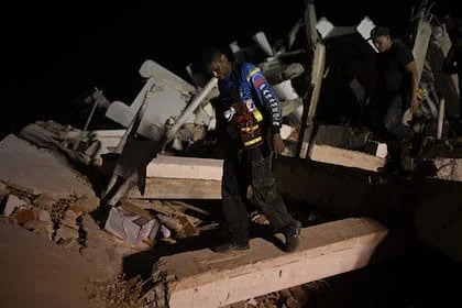 Personas buscan a sus familiares fallecidos entre los escombros de un edificio derrumbado en el barrio Los Corales, en Caraballeda, estado La Guaira, Venezuela, el 1 de julio de 2026