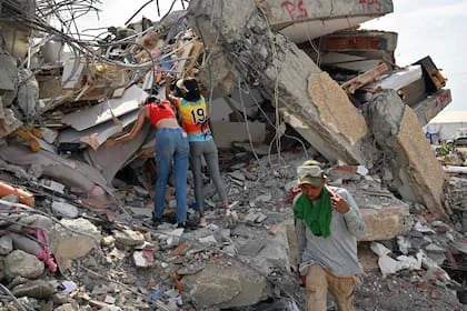 Residentes locales intentan recuperar pertenencias en el lugar del derrumbe de un edificio en Caraballeda, La Guaira, Venezuela, el 2 de julio de 2026