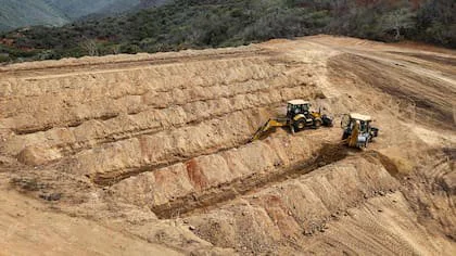 Esta vista aérea muestra excavadoras cavando hileras de fosas para enterrar a las víctimas del terremoto del 24 de junio en el cementerio La Esperanza, en Catia La Mar